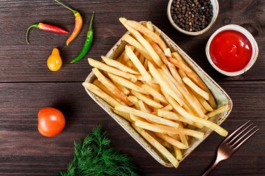 Ketçap ve koyu ahşap zemin üzerine baharat ile pişmiş patates kızartması. İtalyan yemek.