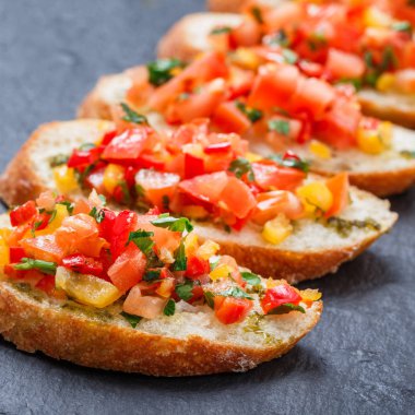 Meze bruschetta ciabatta ekmeği kayrak taş zemin üzerine doğranmış sebze ile kapatın. Lezzetli aperatifler, sandviçler, crostini, kanepe, parti ya da piknik zamanında antipasti. Üstten Görünüm