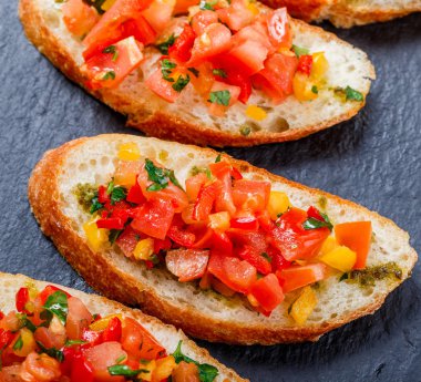 Meze bruschetta ciabatta ekmeği kayrak taş zemin üzerine doğranmış sebze ile kapatın. Lezzetli aperatifler, sandviçler, crostini, kanepe, parti ya da piknik zamanında antipasti. Üstten Görünüm