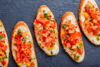 Meze bruschetta ciabatta ekmeği kayrak taş zemin üzerine doğranmış sebze ile kapatın. Lezzetli aperatifler, sandviçler, crostini, kanepe, parti ya da piknik zamanında antipasti. Üstten Görünüm