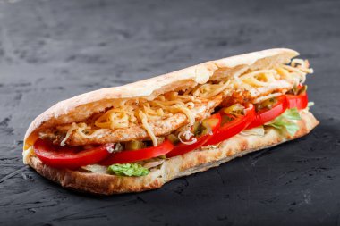 Sandviç taze Pide ızgara fileto tavuk, marul, domates, turşu ve koyu ahşap zemin üzerine peynir dilimleri ile üzerinden. Şaşlık veya şiş kebap. Sağlıklı yemek
