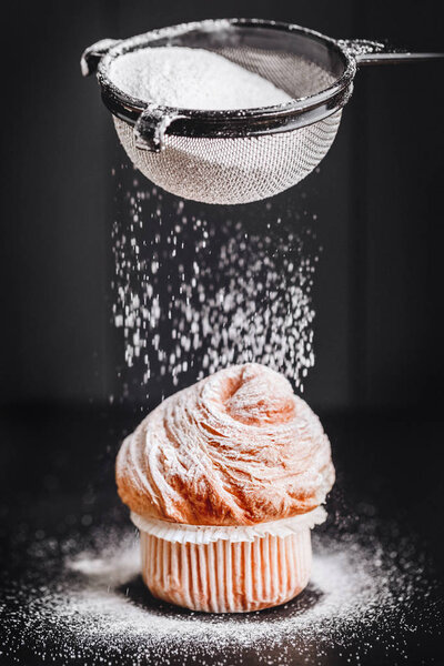 Домашние кексы с сахарной пудрой на черном фоне, избирательный фокус. Домашняя пекарня
.