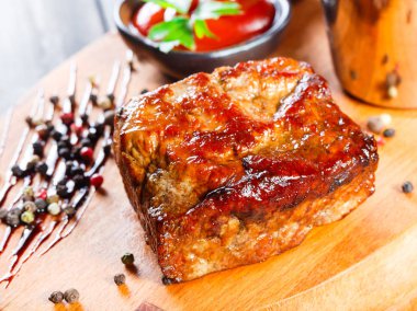 Izgara beaf biftek ahşap kesme tahtası üzerine bir kova içinde sos ve patates kızartması ile.