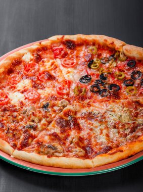 Karışık pizza tavuk, domates, mantar, jambon, salam, zeytin ve koyu ahşap zemin üzerine peynir ile İtalyan yemeği. Ev yapımı pizza. Üstten Görünüm