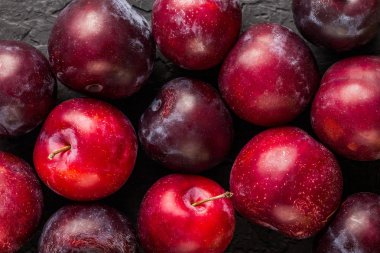 Karanlık taş zemin üzerine taze erik makro. Sağlıklı yaz meyve. Üstten görünüm.