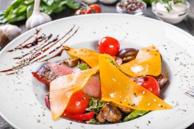 Sığır eti biftek chargrilled Orta nadir kiraz domates, mantar ve peynir koyu ahşap zemin üzerine sıcak salata. Sıcak et yemekleri. Maddeler tablosundaki. Üstten görünüm