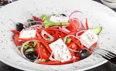 Yunan salatası ile domates, salatalık, kırmızı soğan, zeytin, beyaz peynir ve tatlı biber ahşap arka plan üzerinde organik sebze. Sağlıklı gıda. Üstten görünüm