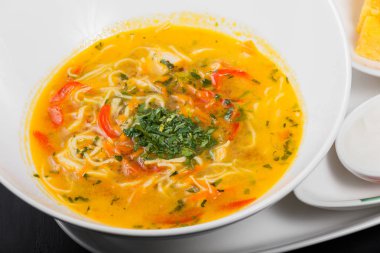 Sebze çorbası, erişte, otlar, maydanoz ve ahşap siyah arka plan, sağlıklı gıda kase sebze suyu. Üstten Görünüm.