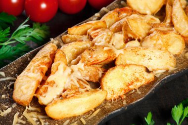 Kavrulmuş ya da fırında patates peynir ve koyu ahşap arka plan üzerinde beyaz tabakta sos ile.