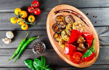 Izgara sebze, mantar, domates, patlıcan, biber ahşap arka plan üzerinde kesme tahtası üzerinde. Sağlıklı gıda. Üstten görünüm.