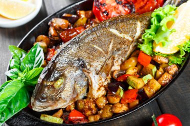 Dorado Balık Fırında sebze ve limon ahşap arka plan üzerinde Pan ile kapatın. Lezzetli yemek deniz ürünleri.
