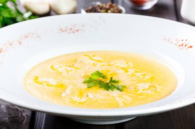 Krem çorbası ile peynir parmesan, otlar ve koyu ahşap arka plan üzerinde tabakta tavuk. Ev yapımı yemek. Maddeler tablosundaki.