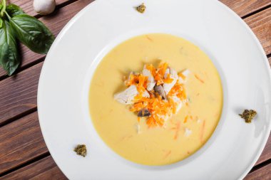 Tavuk göğsü, mantar, koyu ahşap arka plan üzerinde plaka üzerinde otlar ile krem çorbası. Ev yapımı yemek. Maddeler tablosundaki.