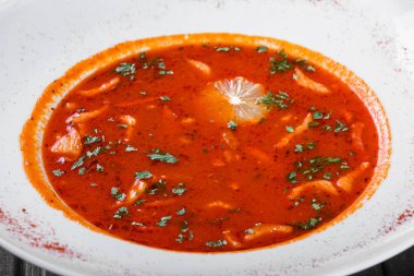 Çorba, et, zeytin, otlar ve limon ekşi krema ile servis tabağı, koyu ahşap arka plan üzerinde biber. Ev yapımı yemek. Maddeler tablosundaki. Geleneksel Rus çorbası - solyanka