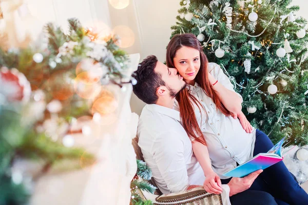 Lyckliga Paret Sitter Vardagsrummet Med Christmas Bok Bakom Inredda Xmas — Stockfoto