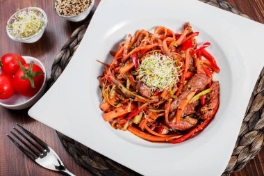 Sıcak salata sığır eti ve ızgara sebzeler, soya sosu ahşap masa üzerinde plaka üzerinde. Sağlıklı gıda. Üstten görünüm.