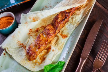 Tavuk kebap pide ekmek, domates sosu ve konyak ahşap arka plan üzerinde. Sıcak et yemekleri. Üstten görünüm.