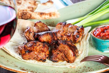 Domates sosu ve Yeşiller ile şarap bir tabakta servis ile sığır eti şiş ızgara. Sıcak et yemekleri. Üstten görünüm.