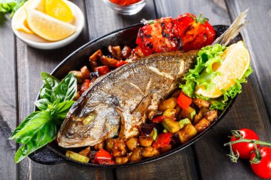 Dorado Balık Fırında sebze ve limon ahşap arka plan üzerinde Pan ile kapatın. Lezzetli yemek deniz ürünleri. Üstten görünüm