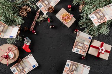 Hediye kutuları, çam dalları, çam kozalakları ve para euro tatil koyu arka plan üzerinde Noel kompozisyonu. Noel ve mutlu yeni yıl tema. Düz yatıyordu, en iyi görünümü