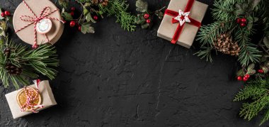 Noel ağacı dalları, hediyeler, çilek, çam kozalakları kar taneleri ile koyu arka plan üzerinde yaratıcı çerçeve yaptı. Noel ve yeni yıl tema. Düz yatıyordu, en iyi görünüm, metin için yer