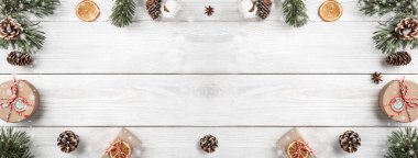 Beyaz ahşap arka planda hediye kutuları, çam kozalakları ile Noel ağacı dalı yaratıcı çerçeve yaptı. Noel ve yeni yıl tema. Düz yatıyordu, en iyi görünüm, metin, geniş kompozisyon için yer