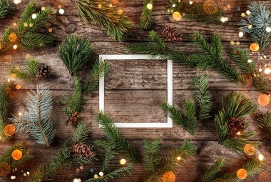 Yaratıcı düzen Noel köknar yapılan kağıt kartı Not ve çam kozalakları ahşap arka plan üzerinde çerçeve ile dalları. Noel ve yeni yıl tema, bokeh, kıvılcım, parlayan. Düz yatıyordu, en iyi görünümü