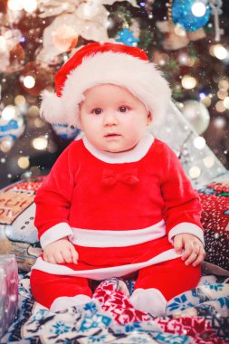 Bebek ilk Noel. Yılbaşı tatil. Bebek hediye ile Santa şapka ile. Noel ağacı ve mevcut hediye kutusu tarafından dekore edilmiş salon, ışık vermek rahat bir atmosfer. Xmas Tema