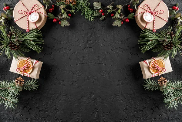 Kreativer Rahmen Aus Weihnachtsbaumzweigen Geschenken Beeren Tannenzapfen Auf Dunklem Hintergrund — Stockfoto