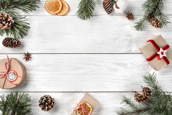 Kreativer Rahmen Aus Weihnachtsbaumzweigen Auf Weißem Holzgrund Mit Geschenkschachteln Tannenzapfen — Stockfoto