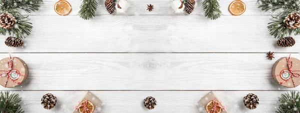 创意框架由圣诞树树枝在白色木背景与礼品盒 圣诞节和新年主题 平面布局 顶部视图 文本空间 宽构图 — 图库照片