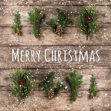 Neşeli Noel tipografik çam dalları, çam kozalakları ve ahşap arka plan üzerinde kar taneleri ile ahşap arka plan üzerinde. Noel ve yeni yıl tema, kar. Düz yatıyordu, en iyi görünümü