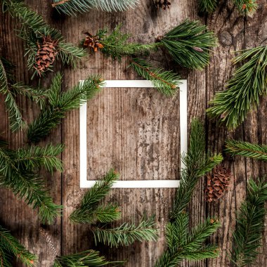 Yaratıcı düzen Noel köknar yapılan dalları çerçeve ile kağıt kartı unutmayın, çam kozalakları ahşap arka plan üzerinde. Noel ve yeni yıl tema. Düz yatıyordu, en iyi görünümü