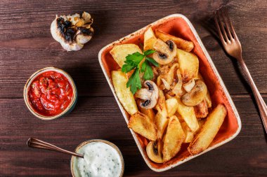 Kavrulmuş patates mantar, otlar, soğan, domates, sos ve koyu ahşap zemin üzerine ekmek. İtalyan yemeği. Üstten görünüm