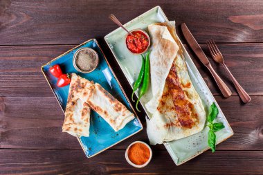 Tavuk kebap pide ekmek, domates sosu ve konyak ahşap arka plan üzerinde. Sıcak et yemekleri. Üstten görünüm