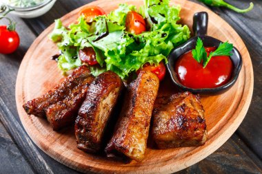 Taze sebze salatası, domates ve ahşap kesme tahtası üzerinde soslu ızgara sığır eti biftek