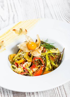 Salata tavuk göğsü ve ızgara sebzeler, patlıcan, tatlı biber, domates, avokado ve ahşap arka plan üzerinde plaka üzerinde physalis kapatın. Üstten Görünüm