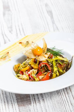 Salata tavuk göğsü ve ızgara sebzeler, patlıcan, tatlı biber, domates, avokado ve ahşap arka plan üzerinde plaka üzerinde physalis kapatın. Üstten Görünüm