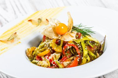 Salata tavuk göğsü ve ızgara sebzeler, patlıcan, tatlı biber, domates, avokado ve ahşap arka plan üzerinde plaka üzerinde physalis kapatın. Üstten Görünüm