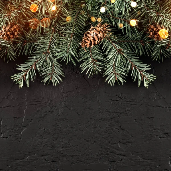 圣诞冷杉分枝与灯光在黑暗的黑色背景 圣诞节和新年快乐卡 平面布局 顶部视图 宽构图 — 图库照片