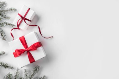 Noel hediye kutuları çam dalları, çam kozalakları, kırmızı kurdele beyaz zemin üzerine. Noel ve mutlu yeni yıl tema. Düz yatıyordu, en iyi görünüm, metin için yer