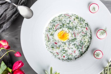 Soğuk çorba ya da turp, salatalık, dereotu ve gri arka plan üzerinde otlar ile yaz yoğurt. Okroshka. Yeme sağlıklı gıda kavramı temiz. Üstten görünüm, düz yatıyordu