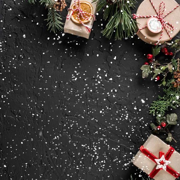 Yaratıcı düzen çerçeve yaptı Noel ağaç dalları, çam kozalakları, koyu arka plan üzerinde hediyeler. Noel ve yeni yıl tema., kar. Düz yatıyordu, en iyi görünüm, metin için yer