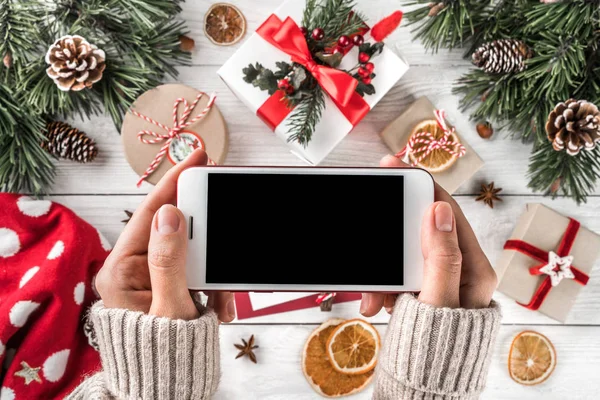 Manos Femeninas Sosteniendo Teléfono Móvil Cajas Regalo Navidad Con Decoración —  Fotos de Stock