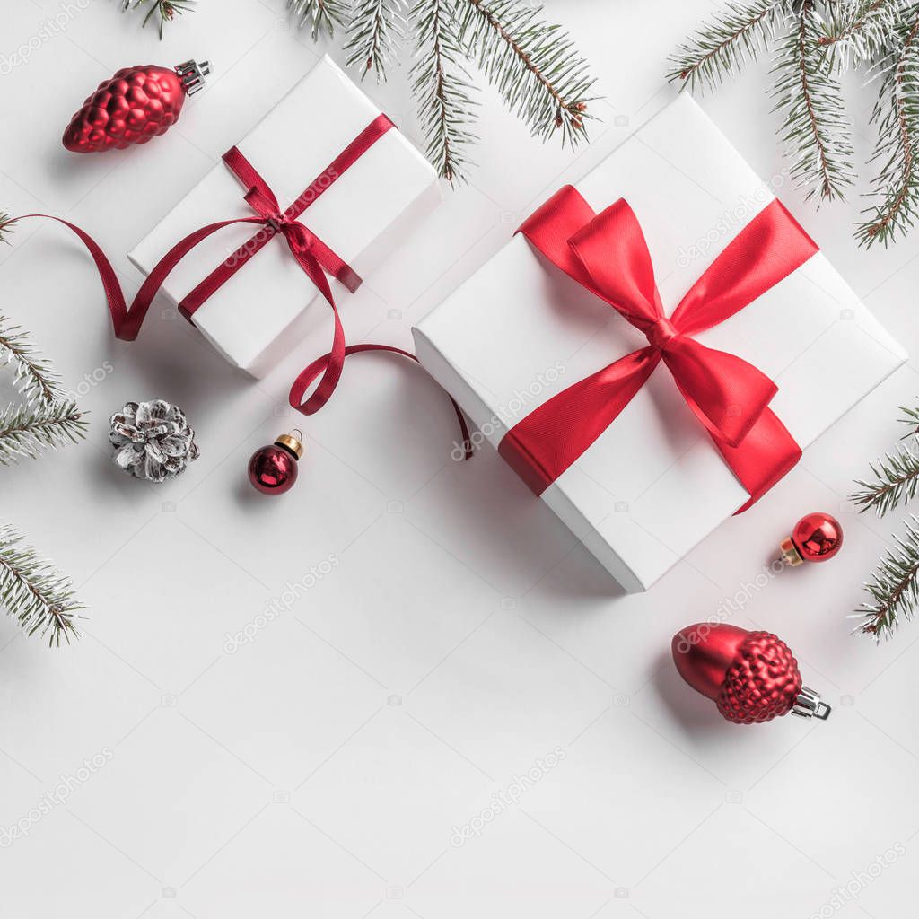 Christmas gift boxes on white background with Fir branches, pine cones, red decoration. Xmas and Happy New Year theme. Flat lay, top view, space for text