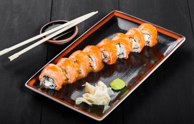 Suşi Roll - somon, salatalık, avokado ve krem peynir koyu ahşap arka plan üzerinde Maki Sushi yapılmış. Üstten Görünüm. Japon mutfağı