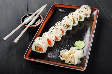 Suşi Roll - somon, turuncu, avokado ve krem peynir koyu ahşap arka plan üzerinde Maki Sushi yapılmış. Üstten Görünüm. Japon mutfağı