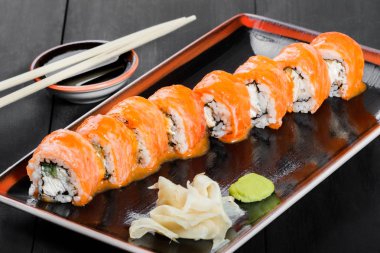 Suşi Roll - somon, salatalık, avokado ve krem peynir koyu ahşap arka plan üzerinde Maki Sushi yapılmış. Üstten Görünüm. Japon mutfağı