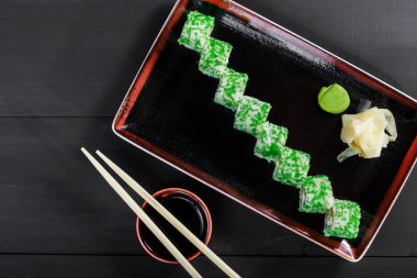 Suşi Roll - yeşil havyar ile Maki Sushi, koyu ahşap zemin üzerine yengeç et, avokado ve krem peynir. Üstten Görünüm. Japon mutfağı