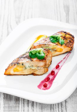 Ahşap arka plan üzerinde plaka üzerinde yumurta ve peynir ile doldurulmuş ızgara tavuk göğsü kapatın. Sıcak et yemekleri. Üstten görünüm